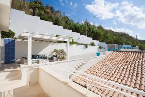 una casa blanca con escaleras blancas y una colina en Ferienhaus für 6 Personen ca 80 qm in Trappeto, Sizilien Nordküste von Sizilien, en Trappeto
