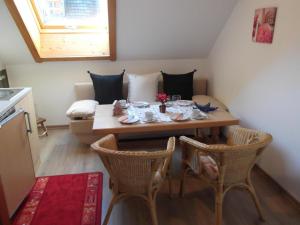 een kleine kamer met een tafel en stoelen en een bank bij Ferienwohnung für 4 Personen 1 Kind ca 50 qm in Unterammergau, Bayern Oberbayern in Unterammergau