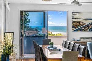 a dining room with a table and chairs with a view of the ocean at Peregian Beach Holiday House & Resort Pet Friendly in Peregian Beach