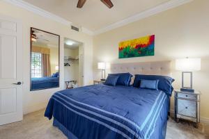 Un dormitorio con una cama azul y una pintura en la pared en La Quinta Leisure, en La Quinta
