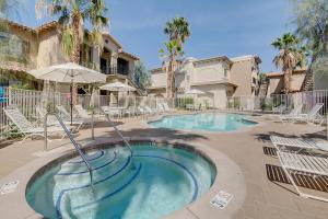 una piscina con sillas y sombrilla en La Quinta Leisure, en La Quinta