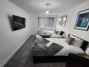 a bedroom with two beds and a flat screen tv at 4 Bedroom 2 Bathroom Shared House - Near BHX and NEC in Birmingham