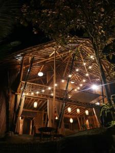 a building with lights on it at night at Eco Bamboo Island Bali - Bamboo House #4 in Selat