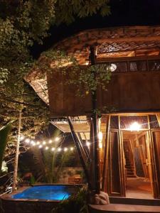 a house with a swimming pool at night at Eco Bamboo Island Bali - Bamboo House #4 in Selat