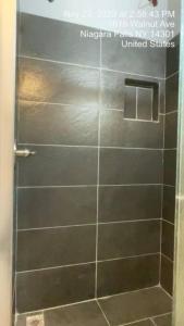 a shower with a glass door in a bathroom at Niagara View- Walnut Av 3 Bd & 2 F. Bth, Free 2prk in Niagara Falls