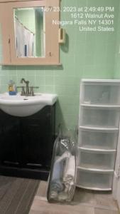 a bathroom with a sink and a mirror and a shelf at Niagara View- Walnut Av 3 Bd & 2 F. Bth, Free 2prk in Niagara Falls