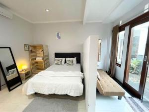 Habitación blanca con cama y ventana en LaGriya Guest House, en Ketewel