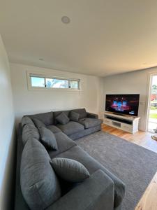 a living room with a couch and a flat screen tv at Eden Explorer - Beach - Bike - Hike - Fish in Eden