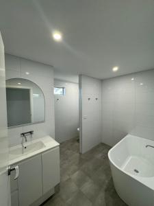 a bathroom with a sink and a tub and a mirror at Eden Explorer - Beach - Bike - Hike - Fish in Eden +25 photos