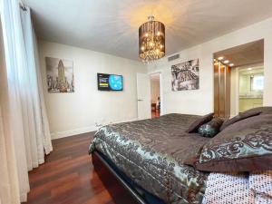 1 dormitorio con cama y lámpara de araña en 1BR Beachfront Condo in Holywood, FL, en Hollywood
