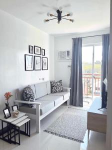 a white living room with a couch and a window at Palawan Paradise Condotel 6F in Puerto Princesa City