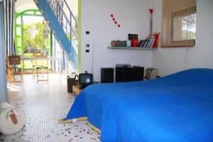 Un dormitorio con una cama azul y una escalera en Wohnung auf zwei Etagen mit Studio und mit Balkonblick ins bergige Grüne, en Monte Vibiano Vecchio