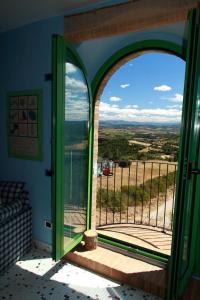una puerta abierta a un balcón con vistas en Wohnung auf zwei Etagen mit Studio und mit Balkonblick ins bergige Grüne, en Monte Vibiano Vecchio