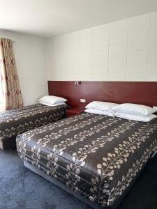 Postel nebo postele na pokoji v ubytování Tudor Motor Lodge