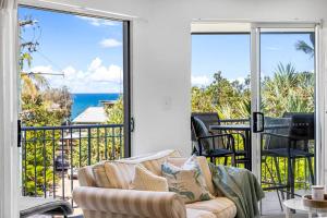 a living room with a couch on a balcony at 3 Andari Sunshine Beach Modern Apt 1 Min Beach in Sunshine Beach