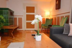 a living room with a couch and a table with white flowers at Ferienwohnung für 6 Personen ca 85 qm in Villingen-Rietheim, Schwarzwald in Villingen-Schwenningen