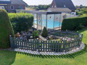 una valla de madera en un patio con piscina en Ferienhaus Kallies - Dat grote Huus en Bornhöved