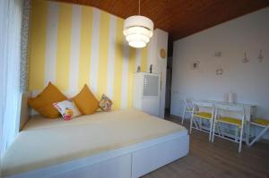 1 dormitorio con 1 cama grande con rayas amarillas y blancas en Ferienwohnung für 4 Personen ca 50 qm in Vantačići, Kvarner Bucht Krk, en Vantačići