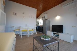 Una sala de estar con una mesa y una cocina. en Ferienwohnung für 4 Personen ca 50 qm in Vantačići, Kvarner Bucht Krk, en Vantačići