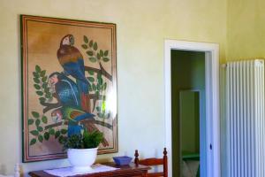 een schilderij van een pauw aan de muur in een kamer bij Wohnung in Cascina mit Privatem Garten in Cascina
