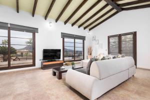 a living room with a white couch and a tv at Ferienhaus in Tuineje mit Großer Terrasse in Tesejerague