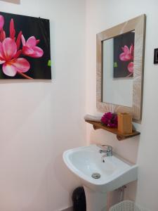 uma casa de banho com um lavatório e um espelho em Terei-Here Bungalow Airport em Avae