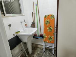 a bathroom with a sink and a surfboard at Lindo apartamento em Icaraí perto de tudo. in Niterói