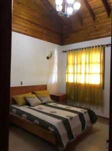 a bedroom with a large bed with a window at Villa Santiago , La Loma de Ranchito Pichey in Santiago de los Caballeros