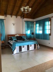 um quarto com uma cama num quarto com cortinas azuis em Villa Santiago , La Loma de Ranchito Pichey em Santiago de los Caballeros