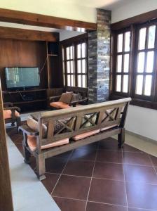 a living room with a bench and a television at Villa Santiago , La Loma de Ranchito Pichey in Santiago de los Caballeros