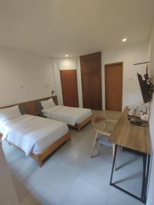 a hotel room with two beds and a desk at Djajanti House in Semarang