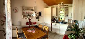 una piccola cucina con tavolo in legno e una sala da pranzo di Ferienhaus in Sehestedt mit Kleinem Garten a Sehestedt
