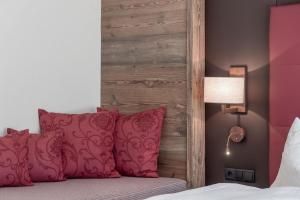 a bed with pink pillows and a wooden headboard at Ferienwohnung für 5 Personen ca 65 qm in Sölden, Tirol Skigebiet Sölden in Sölden