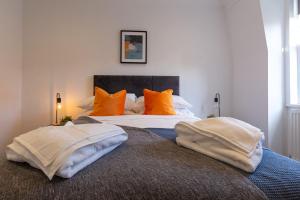 a bedroom with two beds with orange pillows at Cosy Central 2 Bedroom - Near Brighton Beach & Shops! in Brighton & Hove