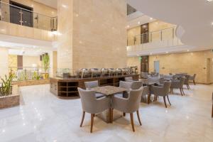 Sīdī Ḩamzahにあるسدو بوتيك للشقق الفندقيةのロビーのテーブルと椅子付きのレストラン