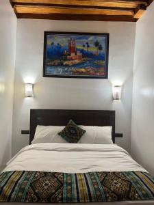 1 dormitorio con 1 cama con una pintura en la pared en Riad el wazania, en Rabat