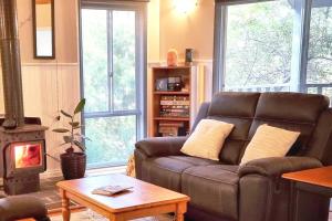 - un salon avec un canapé et un poêle à bois dans l'établissement Poolway Cottage Hepburn Springs, à Hepburn Springs