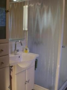 a white bathroom with a sink and a shower at Ferienhaus in Kuhklingen mit Großer Terrasse in Wald-Michelbach