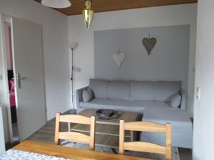 uma sala de estar com um sofá e duas cadeiras em Tolles Appartement in Weißenstadt mit Offenem Kamin em Weißenstadt