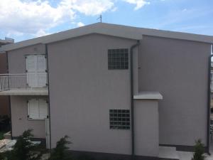 a white building with a cross on top of it at Strandnahe Ferienwohnung mit Balkon und Gemeinschaftspool, in der Nähe des Naturparks Velebit in Cesarica