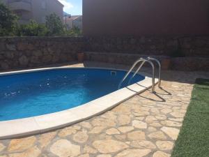 una piscina con barra de metal al lado de un edificio en Strandnahe Ferienwohnung mit Balkon und Gemeinschaftspool, in der Nähe des Naturparks Velebit en Cesarica