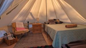 a bedroom with a tent with a bed and a chair at La Window Glamping in La Ventana