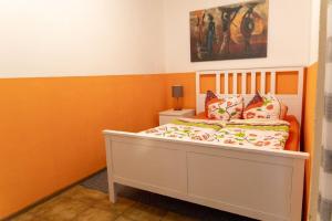 a bed in a room with orange and white walls at Ferienwohnung mit Balkon, zwei Schlafzimmern und Küche mit Geschirrspülmaschine in Weißenstadt