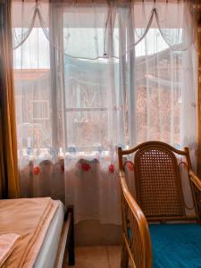 a room with a window with curtains and a table and chairs at Brussels Homestay Kost in Balige