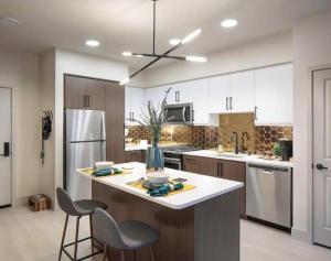 a kitchen with white cabinets and a large island with chairs at Huge 2bd Apt Near Disneyland and Anaheim Conv Center in Santa Ana