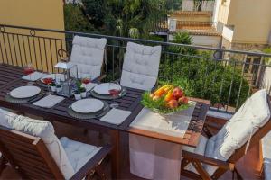 un tavolo con un cesto di frutta sul balcone di Ferienwohnung für 8 Personen ca 240 qm in Taormina, Sizilien Ostküste von Sizilien a Taormina
