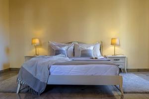 una camera da letto con un grande letto con due tavoli e due lampade di Ferienwohnung für 8 Personen ca 240 qm in Taormina, Sizilien Ostküste von Sizilien a Taormina