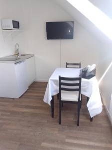 une salle à manger avec une table et une cuisine dans l'établissement Hotel Le Paddock, à Magny-Cours