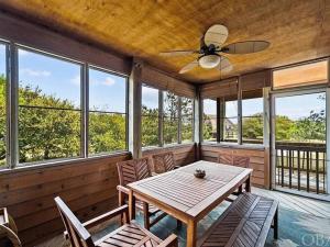 a dining room with a ceiling fan and windows at 5 Bedroom Beach House 12 Minutes from Beach w/ Firepit & BBQ Grill in Nags Head