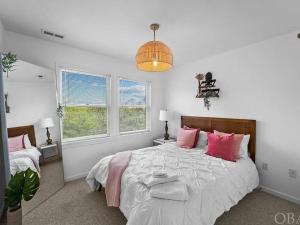 a bedroom with a large bed with pink pillows at 5 Bedroom Beach House 12 Minutes from Beach w/ Firepit & BBQ Grill in Nags Head